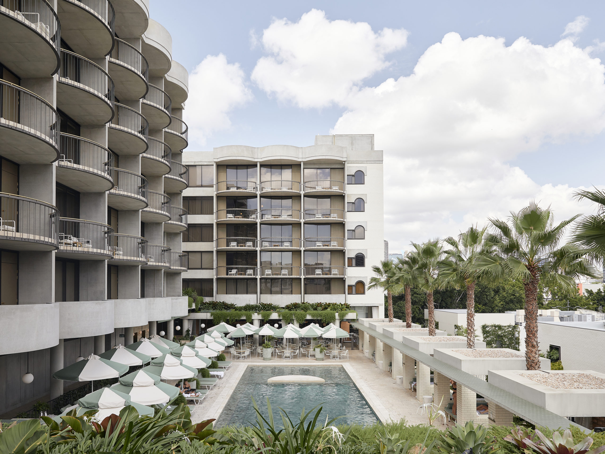 The Calile's curved balconies above the pool deck, photographed mid-morning.