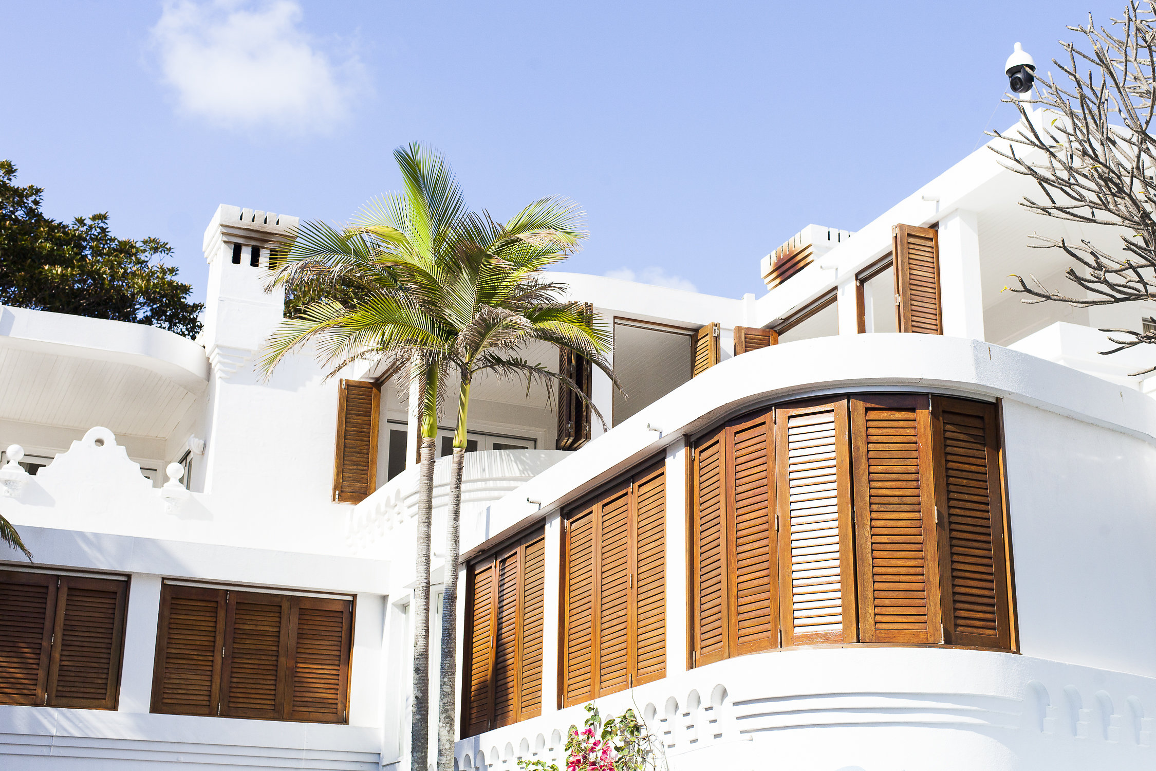 The white architecture and shutters of Raes on Wategos, photographed from the lower terrace.